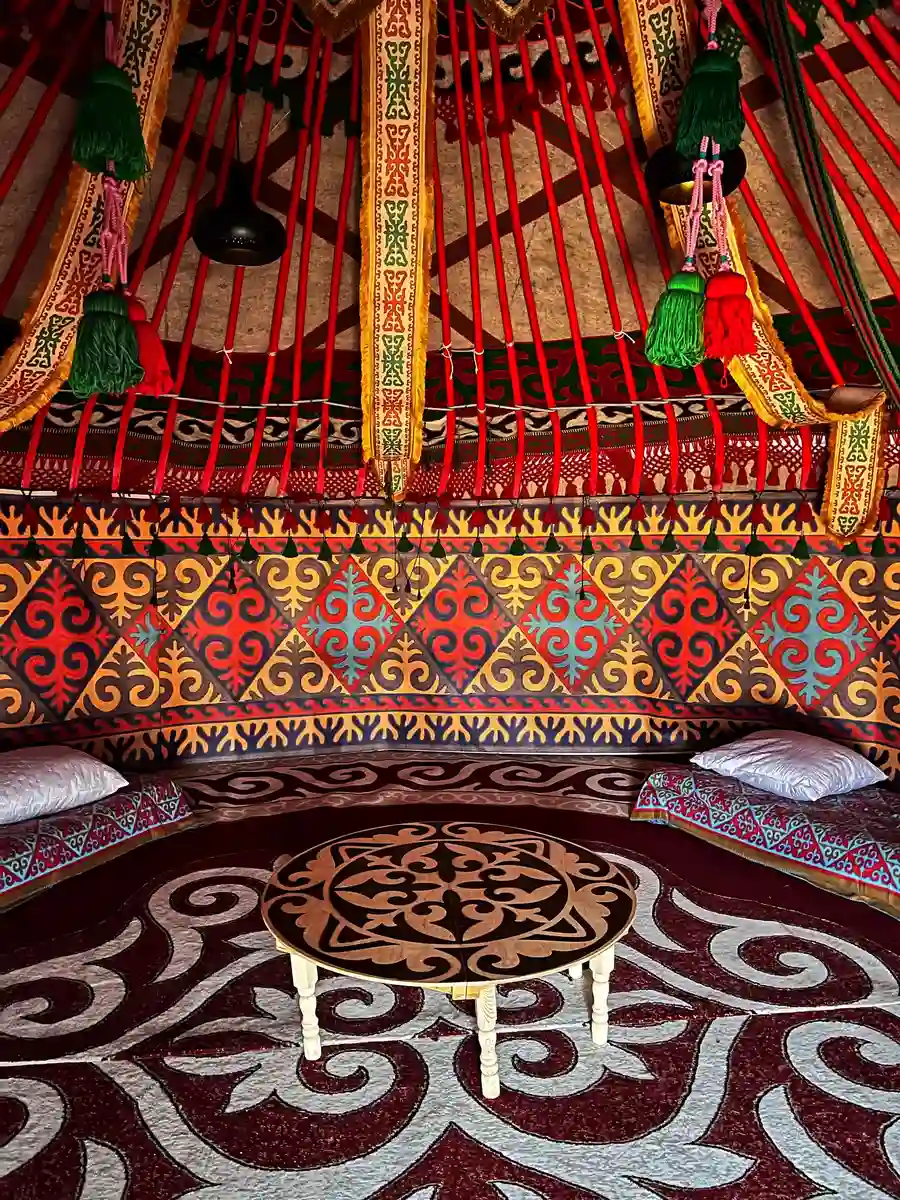 Traditional low round table on a Kazakh patterned carpet inside a yurt